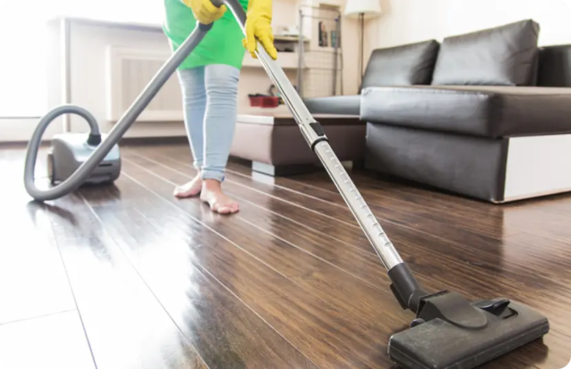 A woman vacuuming a hardwood floor